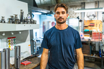 Portrait of a young manual worker in a cnc factory