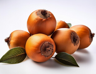 Fototapeta premium Fresh medlar fruit arranged with green leaves on a white background for a colorful display of nature's bounty
