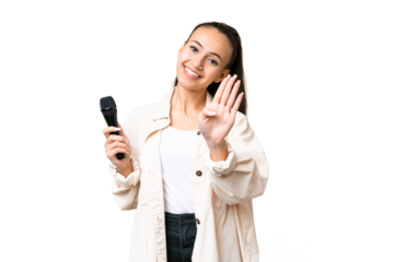 Young singer woman picking up a microphone over isolated chroma key background happy and counting four with fingers