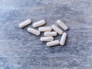 Beta-alanine capsules. Bodybuilding food supplements on wooden background. Top view. Soft focus....