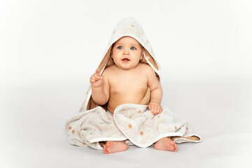 a baby in a towel on a white isolated background, a place for text, a baby wrapped in a sick bath towel after bathing or bathing