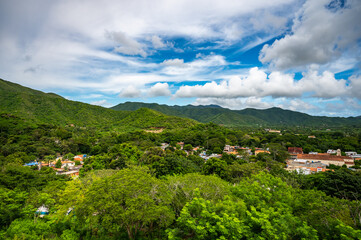 A lush green mountain range with a small town in the valley below