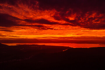 Sunset with amazing clouds and silhouette of coastline.