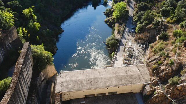 Aerial view of the B&aacute;rcena dam and the hydroelectric power station at the bottom generating renewable energy thanks to the force of the water that returns to the river creating whirlpools