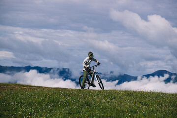 Naklejka premium Asian woman riding mountain bike on beautiful mountain top