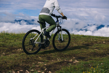 Obraz premium Asian woman riding mountain bike on beautiful mountain top