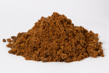 monticulo de azucar mascabo en primer plano, con textura granulada y color marron oscuro, sobre un fondo blanco