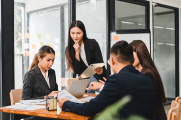 Collaborative business meeting with professionals discussing strategies and analyzing data. team is engaged and focused on their tasks, showcasing teamwork and productivity