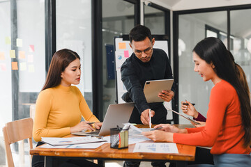 Collaborative business meeting with professionals discussing data analysis. team is engaged, using laptops and tablets to share insights and strategies