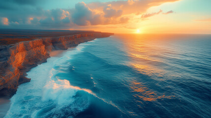 Fototapeta premium Sunset Symphony at the Cliff's Edge: An aerial view of a breathtaking sunset painting the sky in vibrant hues of orange and pink, casting a golden glow on the dramatic cliffs and crashing waves.