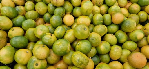Tangerines displayed in a pile for sale in a vegetable market