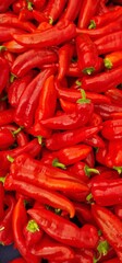 red pepper with green stem in a pile for sale