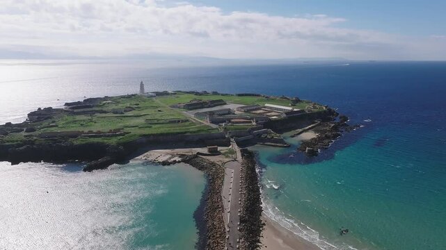 Aerial view of Tarifa, Spain, featuring the Isla de las Palomas lighthouse, the Strait of Gibraltar, and Morocco across the water.