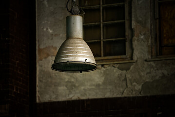 Obraz premium Old industrial lamp hanging in abandoned factory