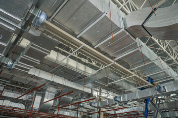 Air conditioning and ventilation system work, duct pipes covered with moisture-proof insulation on the factory ceiling