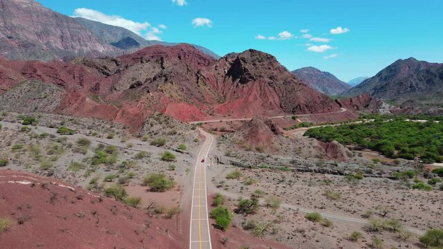 Car riding through eroded mountain landscape of Quebrada Las Conchas in Salta, Argentina