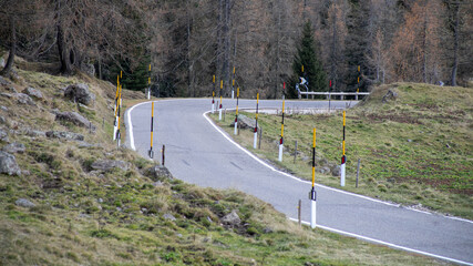 A winding mountain road in alpine terrain, illustrating the concept of travel challenges and scenic...