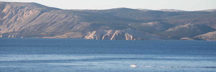 A serene view of the Adriatic Sea against rocky Croatian mountains, ideal for promoting...