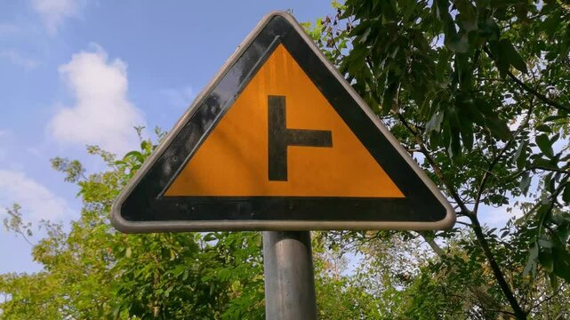 Traffic sign about T-shaped intersection in the forest,indicating Right side intersection having cars,warning to drive slow
