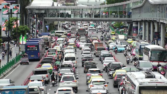 BANGKOK, THAILAND - AUGUST 2024 : High angle view of traffic jam in busy rush hour at downtown shopping area. Transportation and street traffic concept video.