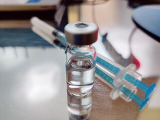 Vaccine in a bottle with a syringe on a medical background.The concept of medicine, healthcare and...