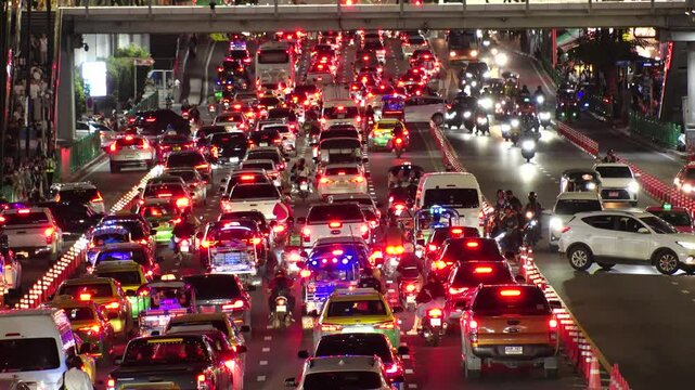 BANGKOK, THAILAND - AUGUST 2024 : View of traffic jam at night. Busy rush hour at downtown shopping area. Transportation and street traffic concept video.