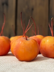 Ripe paradise apples on the table. Small apples with tails on the table. A close-up of paradise apples.