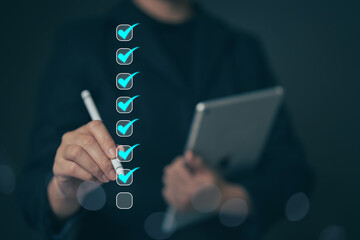 Business performance checklist concept Young business woman using laptop surveys online checklist...