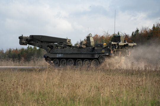 British army Challenger II 2 Titan Armoured Vehicle Launcher Bridge (AVLB) moving along a dirt track at speed