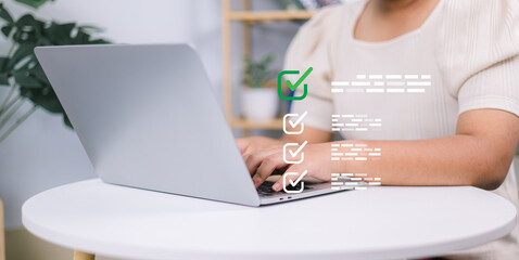 Woman working on laptop and tablet productivity checklist and filling survey form online. Document...