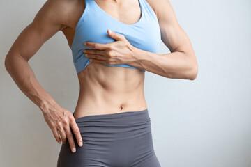 Six-packs abs, V line or V cut abdominal muscle, strong fit healthy happy Asian woman with strong...