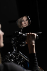 Naklejka premium Woman’s reflection in motorcycle mirror against dark background