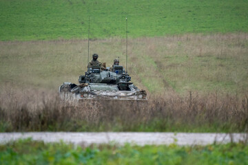 Fototapeta premium commander and gunner directing a British army Warrior FV510 IFV in action on a military exercise