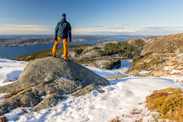 Fototapeta premium Single male hiker looking out across Fløyen mountains and Bergen Fjord, Norway
