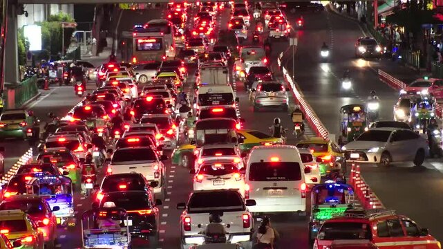 BANGKOK, THAILAND - AUGUST 2024 : High angle time lapse shot of traffic jam at night. Busy rush hour at downtown shopping area. Transportation and street traffic concept video.