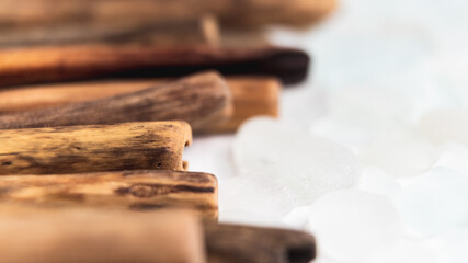 Driftwood sticks arranged in warm tones, contrasted by delicate sea glass pieces, creating a peaceful and balanced display of natural textures. Perfect for organic backgrounds or eco-inspired designs