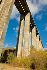 A towering, symmetrical concrete structure of a bridge extends skyward, showcasing architectural beauty in construction.