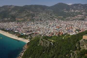 Obraz premium Landscape with harbor and Red tower in Alanya peninsula. Aerial view on city Alanya in southern coast of Turkey. Antalya district.