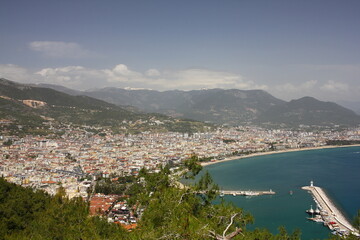 Obraz premium Landscape with harbor and Red tower in Alanya peninsula. Aerial view on city Alanya in southern coast of Turkey. Antalya district.