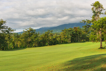 Obraz premium Panorama View of Golf Course with putting green in Taman Dayu Pandaan, Pasuruan, East Java, Indonesia. Golf course with a rich green turf beautiful scenery.