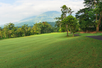 Obraz premium Panorama View of Golf Course with putting green in Taman Dayu Pandaan, Pasuruan, East Java, Indonesia. Golf course with a rich green turf beautiful scenery. 