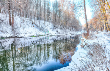 Fantastic  landscape in city park with snowy trees and beautiful frozen river.