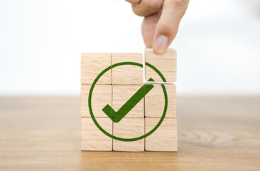 A wooden cube featuring a green checkmark. compliance and regulations. achieving objectives and achieving corporate success. Finishing the task. business ethics. Quality and the ISO symbol.