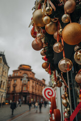 Fototapeta premium Christmas in the city, outdoor festive decor with golden Christmas balls, New Year winter composition