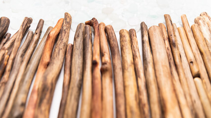 Line of weathered driftwood sticks reaching towards the top of the frame, showcasing natural texture and rustic charm, ideal for creative projects, organic aesthetics, and textured background designs