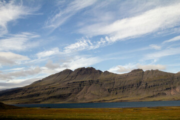 Majestic Icelandic mountains towering over the landscape, with rugged peaks and vibrant green valleys, showcasing the stunning natural beauty of Iceland's highland terrain.