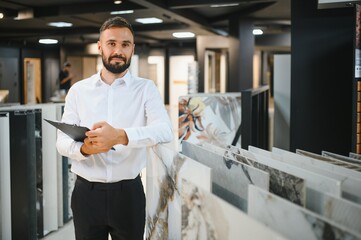 A male seller of ceramic tiles in a hardware store
