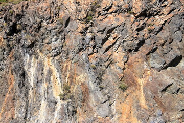 Fototapeta premium gray red yellow rock face close-up, mountain in nature