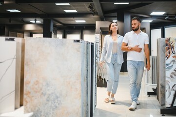 Young couple choosing tiles at building market