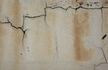 Fototapeta premium Wall with visible cracks and peeling paint highlighting wear and tear on an exterior surface in a weathered structure